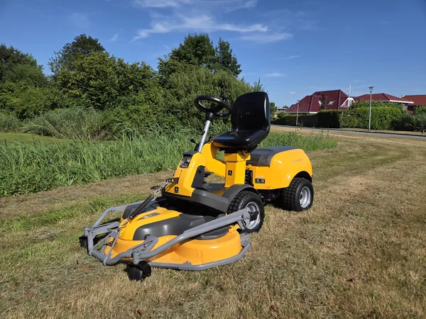 Gele zitmaaier met frontmaaidek op een grasveld