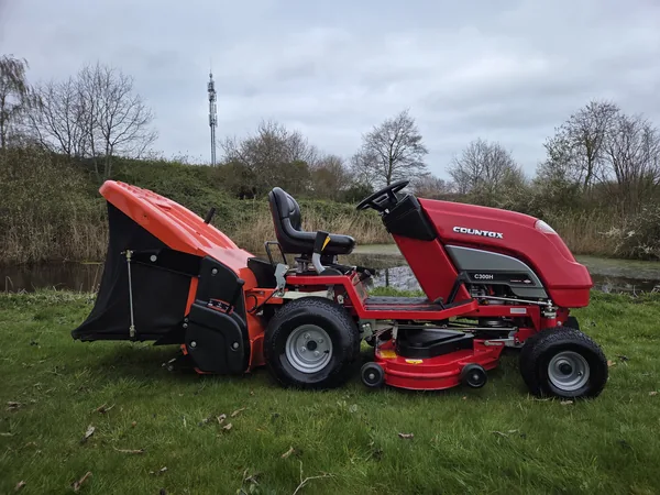 Rode zitmaaier met opvangbak op het gras